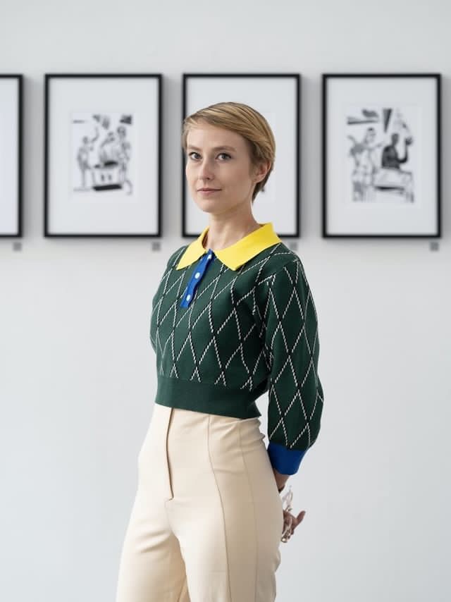 “200 Revelations” exhibition by Sylwia Zawiślak at Raster Gallery, Warsaw, 2022. Linocut prints depicting symbolic figures are displayed on the walls. Visitors are viewing the artworks.
